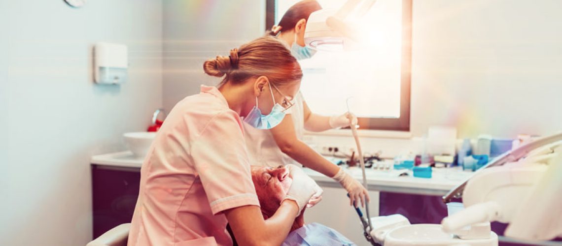 two nurses placing dental implants for a dental patient.